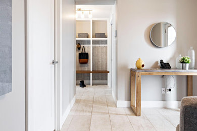 Esempio di un corridoio minimal di medie dimensioni con pareti beige, pavimento con piastrelle in ceramica, pavimento beige, una porta a due ante e una porta marrone