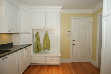 Mid-sized elegant medium tone wood floor entryway photo in DC Metro with yellow walls and a white front door