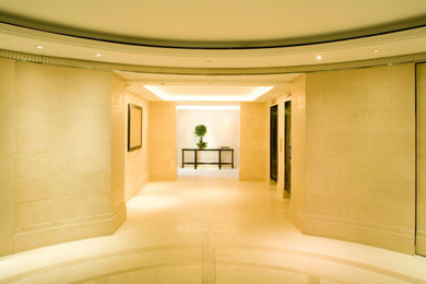 Foyer - huge modern limestone floor foyer idea in New York with beige walls