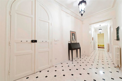 Idées déco pour une entrée contemporaine avec une porte blanche et un sol en marbre.