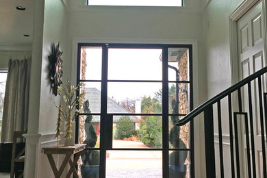 Entryway - mid-sized traditional medium tone wood floor and brown floor entryway idea in Oklahoma City with beige walls and a glass front door