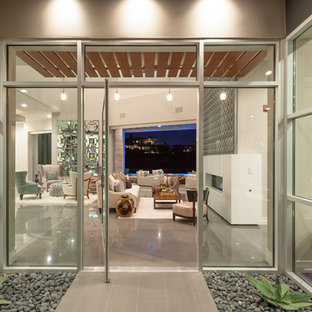 Entryway - large contemporary ceramic tile entryway idea in Las Vegas with beige walls and a glass front door