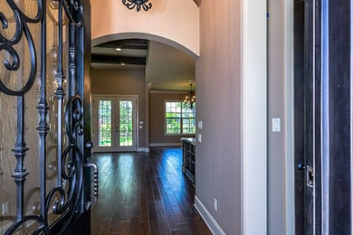 Mittelgroßes Rustikales Foyer mit beiger Wandfarbe, dunklem Holzboden, Einzeltür, schwarzer Haustür und braunem Boden in Sonstige