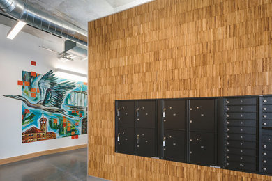 Foto de distribuidor contemporáneo de tamaño medio con paredes amarillas, suelo de madera clara, puerta simple, puerta gris y suelo gris