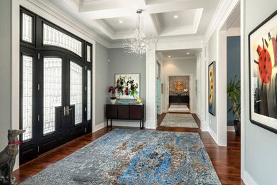 Entryway - large transitional medium tone wood floor entryway idea in Miami with blue walls and a black front door