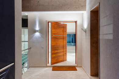 Foto de entrada actual con puerta pivotante y puerta de madera en tonos medios