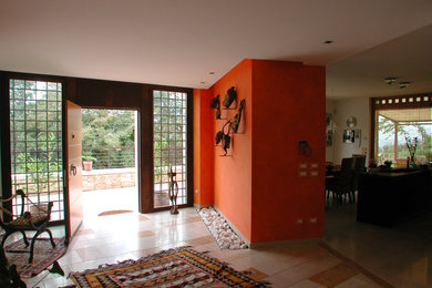 Ispirazione per un grande ingresso o corridoio boho chic con pareti arancioni e pavimento in marmo