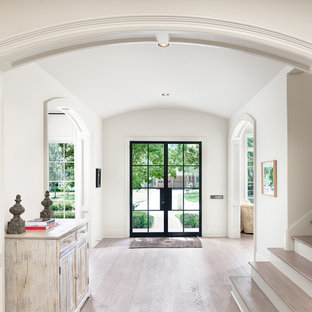 Foto di un grande ingresso country con una porta a due ante, una porta in vetro, pareti bianche, parquet chiaro e pavimento beige