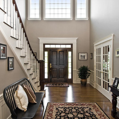 Inspiration for a timeless dark wood floor and brown floor entryway remodel in New York with a dark wood front door and beige walls