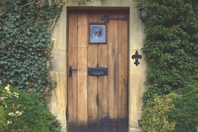 Ejemplo de puerta principal rústica de tamaño medio con paredes beige, puerta simple y puerta de madera en tonos medios