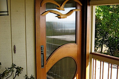 Example of a mid-sized beach style front door design in San Luis Obispo with a dark wood front door