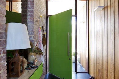パースにある中くらいなミッドセンチュリースタイルのおしゃれな玄関 (緑のドア、黒い床) の写真