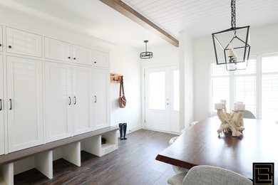 Example of a country medium tone wood floor and brown floor entryway design in Toronto with white walls and a white front door
