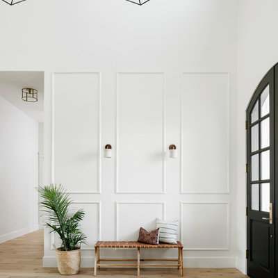 Example of a large transitional light wood floor and beige floor entryway design in Phoenix with white walls and a black front door