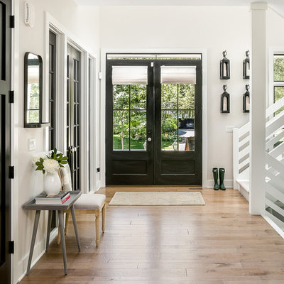 Cottage brown floor entryway photo in Chicago with white walls and a black front door