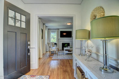 ウィルミントンにあるお手頃価格の小さなトラディショナルスタイルのおしゃれな玄関ロビー (白い壁、無垢フローリング、グレーのドア、茶色い床) の写真