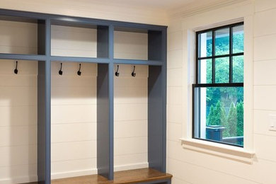 Design ideas for a medium sized classic boot room in Boston with white walls, medium hardwood flooring and brown floors.