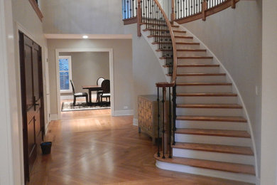 Example of a large classic medium tone wood floor foyer design in Chicago with gray walls