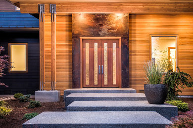 Diseño de puerta principal contemporánea con suelo de cemento, puerta doble y puerta de madera en tonos medios