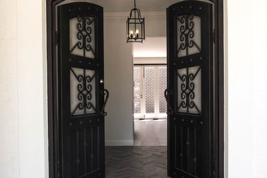 メルボルンにある高級なインダストリアルスタイルのおしゃれな玄関ドア (白い壁、磁器タイルの床、黒いドア、グレーの床) の写真