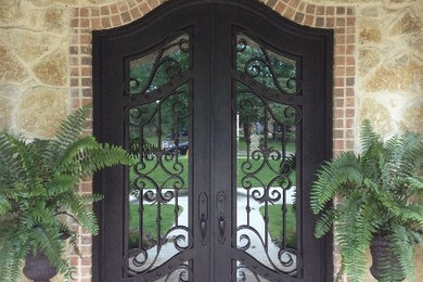 На фото: входная дверь среднего размера в средиземноморском стиле с двустворчатой входной дверью и черной входной дверью