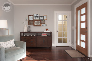 Modelo de distribuidor vintage grande con paredes grises, suelo de madera oscura, puerta simple y puerta de madera en tonos medios