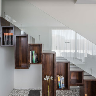 Diseño de escalera recta, moderna, con escalones de madera, contrahuellas de madera y barandilla de vidrio