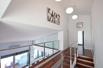 Cette image montre un grand escalier droit minimaliste avec des marches en bois et des contremarches en bois.