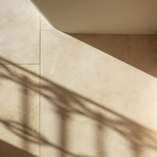 Immagine di una scala a "U" minimal di medie dimensioni con pedata in pietra calcarea e alzata in pietra calcarea