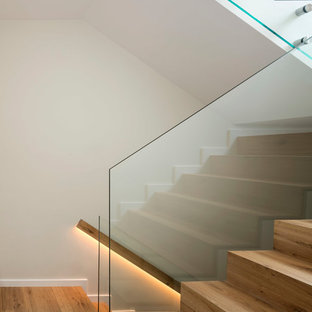 Foto de escalera en U, escandinava, de tamaño medio, con escalones de madera, contrahuellas de madera y barandilla de vidrio