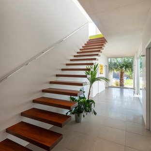 Diseño de escalera suspendida, contemporánea, sin contrahuella, con escalones de madera y barandilla de metal