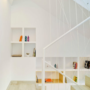 Modelo de escalera en U, contemporánea, con escalones de madera, contrahuellas de madera y barandilla de metal