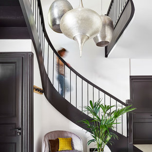 Cette image montre un escalier courbe méditerranéen avec un garde-corps en bois.