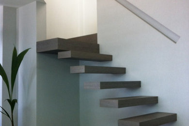 Diseño de escalera en L actual de tamaño medio sin contrahuella con escalones de madera