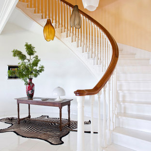 Imagen de escalera curva, bohemia, con escalones de madera pintada, contrahuellas de madera pintada y barandilla de madera