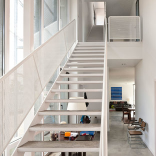 Imagen de escalera recta, minimalista, grande, sin contrahuella, con escalones de metal y barandilla de metal