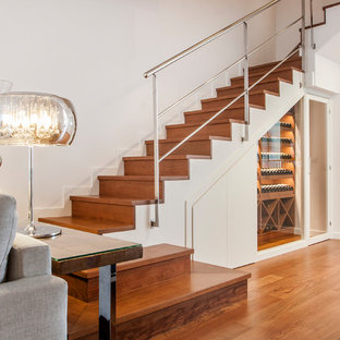 Diseño de escalera en U, actual, con escalones de madera, contrahuellas de madera y barandilla de metal