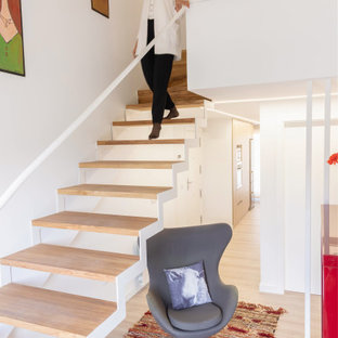 Diseño de escalera suspendida, contemporánea, sin contrahuella, con escalones de madera y barandilla de metal