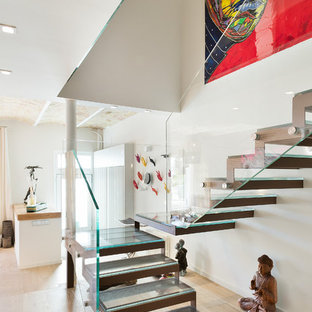 Imagen de escalera en U, contemporánea, grande, sin contrahuella, con escalones de vidrio y barandilla de vidrio