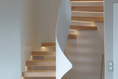 Imagen de escalera en U minimalista de tamaño medio sin contrahuella con escalones de madera y barandilla de metal