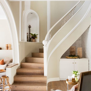 Diseño de escalera curva, costera, con escalones de madera y contrahuellas de madera