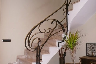 Ejemplo de escalera curva clásica de tamaño medio con escalones con baldosas