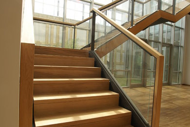 Imagen de escalera en L actual grande con escalones de madera y contrahuellas de madera