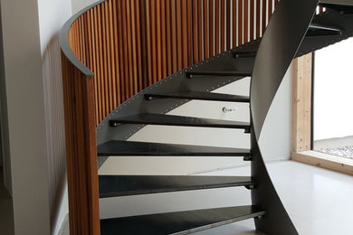 Diseño de escalera de caracol moderna grande sin contrahuella con escalones de metal