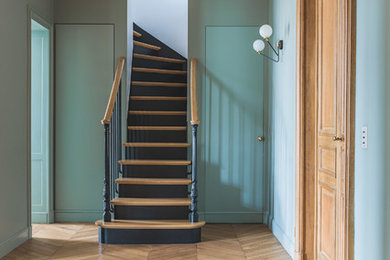 Пример оригинального дизайна: изогнутая деревянная лестница в стиле неоклассика (современная классика) с деревянными ступенями и деревянными перилами