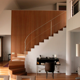 Idée de décoration pour un grand escalier courbe minimaliste avec des marches en bois et des contremarches en bois.