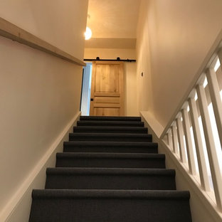 Gewendelte, Mittelgroße Moderne Treppe mit Teppich-Treppenstufen, Teppich-Setzstufen und Holzgeländer in Paris