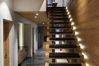 Diseño de escalera rústica con escalones de madera y contrahuellas de metal