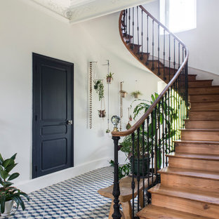 Cette image montre un escalier courbe bohème de taille moyenne avec des marches en bois, des contremarches en bois et un garde-corps en matériaux mixtes.