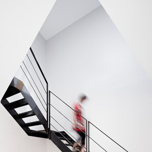 Réalisation d'un grand escalier sans contremarche courbe design avec des marches en métal.